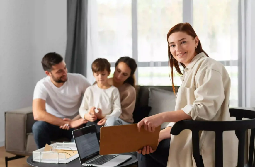 Family consulting a professional woman holding a clipboard during a meeting at home.
